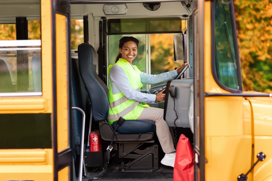School bus driver in a safety vest at the wheel